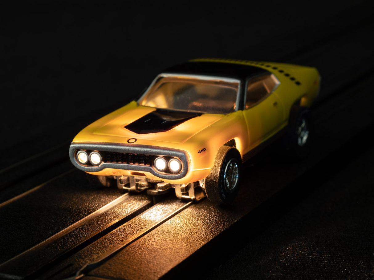 Yellow slot car on track with illuminated headlights for Auto World SC366