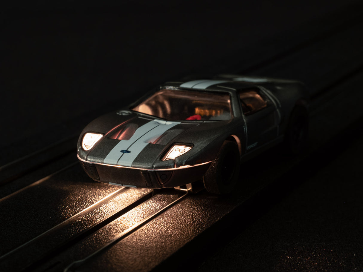 Black and white race car toy on a track, illuminated by warm light for Auto World SC366