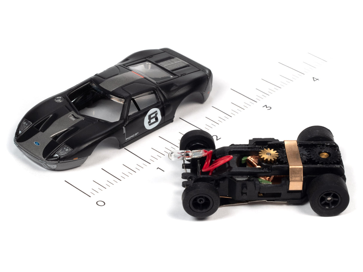 Black and red remote-controlled cars on a ruler for scale for Auto World SC366