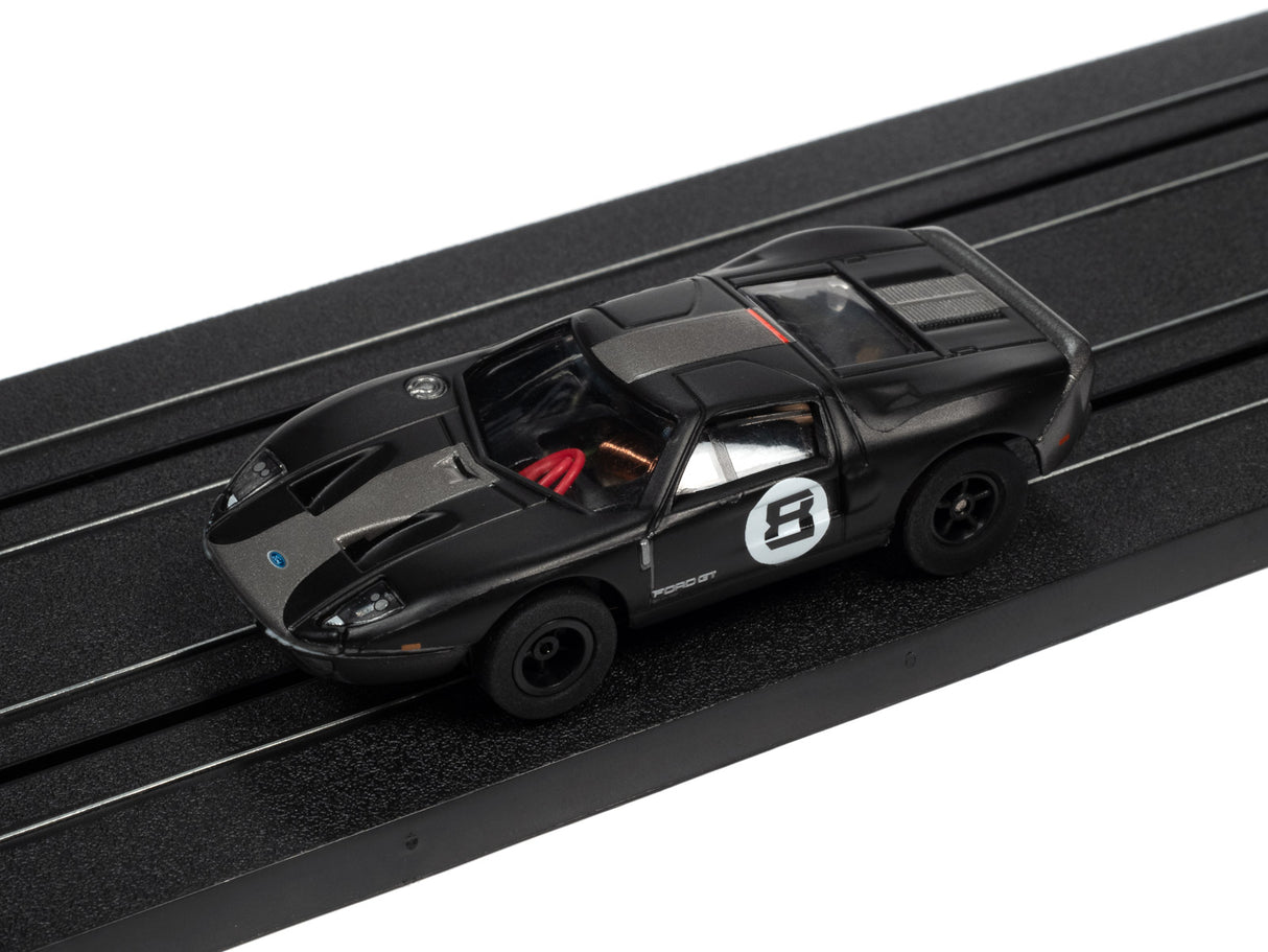 Black race car toy on a black track for Auto World SC366