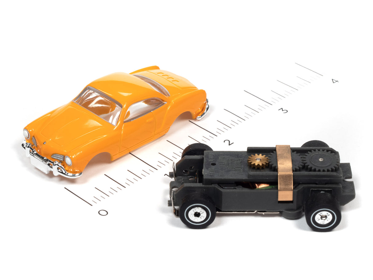 Orange toy car and black toy car with visible gears on a ruler for Auto World SC367