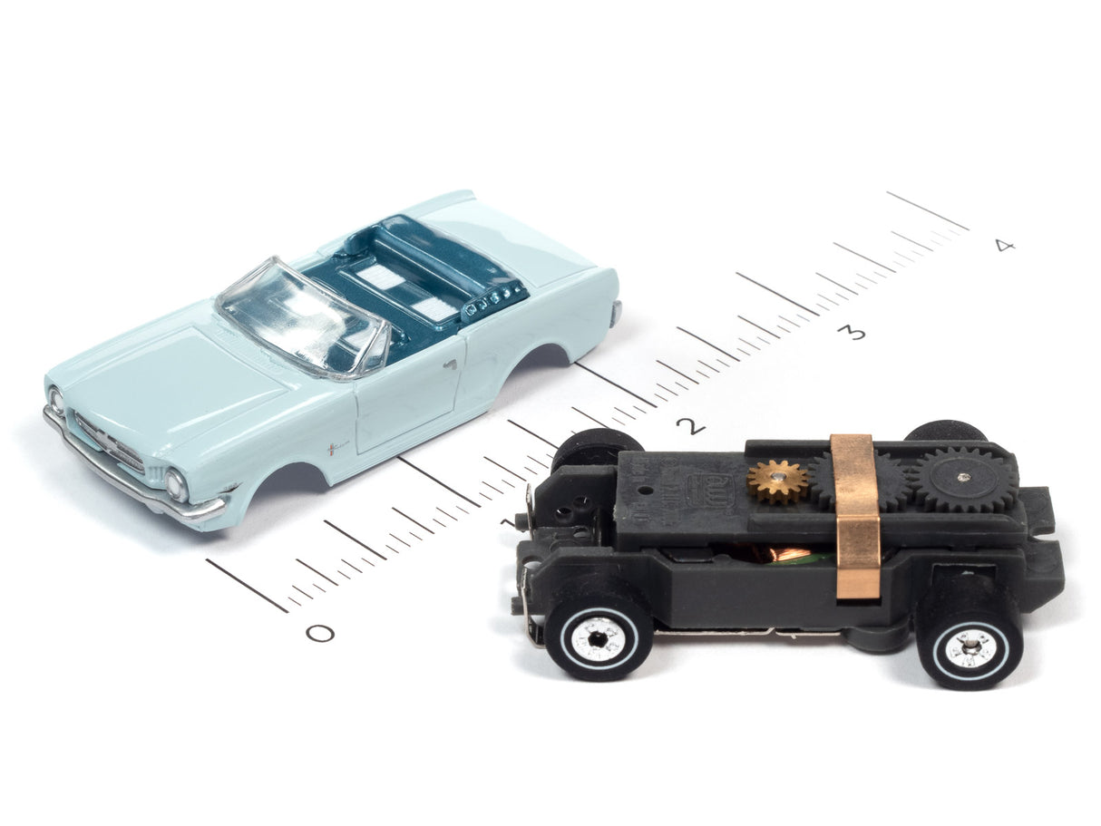 Toy cars: light blue sedan and black, mechanical vehicle on a ruler for Auto World SC367