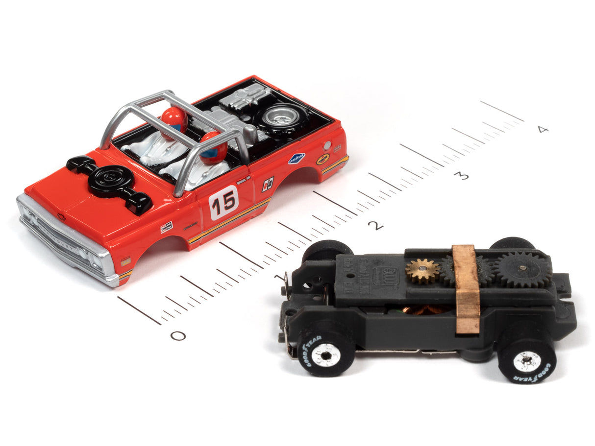 Red and black toy car and black toy vehicle on a ruler for Auto World SC367
