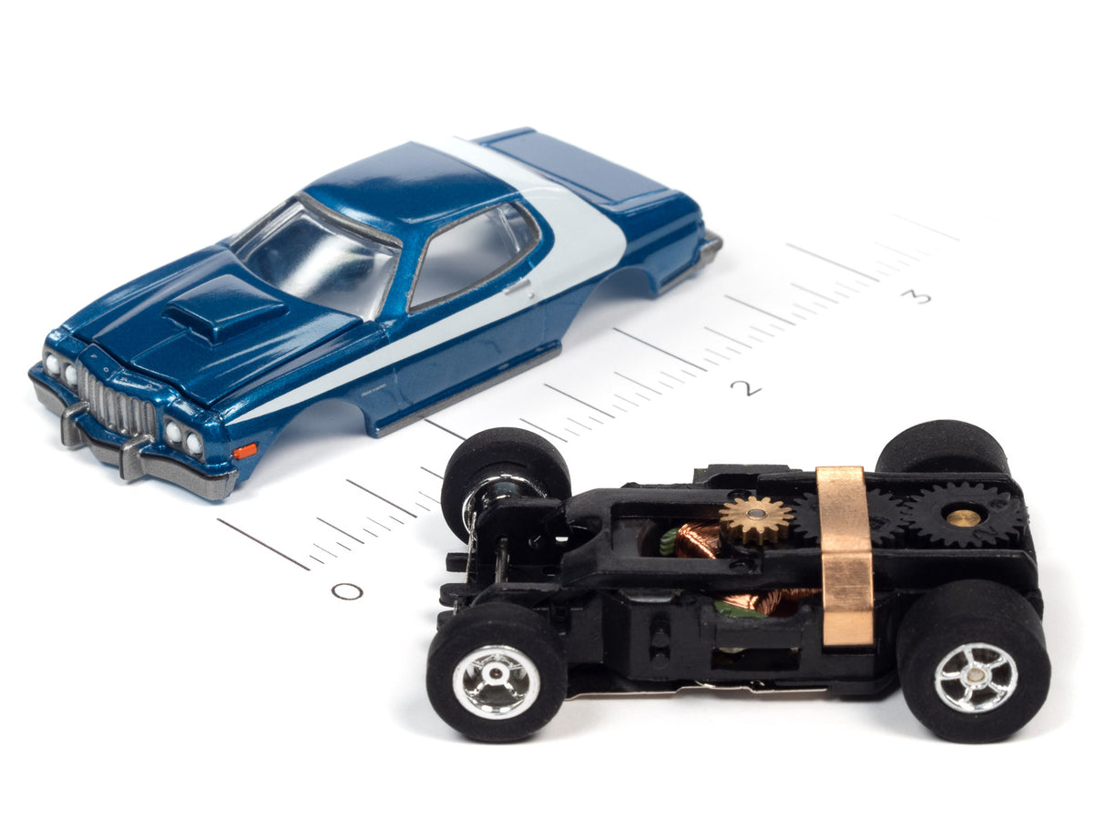 Blue slot car next to its disassembled chassis showing gears for Auto World SC368