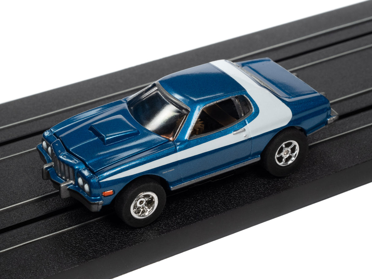 Blue and white slot car on a black track for Auto World SC368