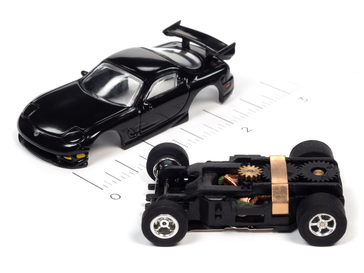 Black slot car model with exposed undercarriage showing mechanical parts for Auto World SC368