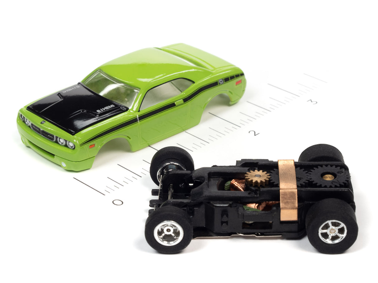 Green slot car and exposed black car chassis on a ruler for Auto World SC368