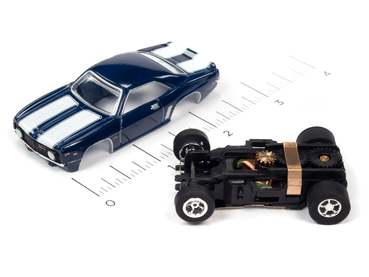 Blue and white slot car next to a black, open-frame car chassis for Auto World SC373