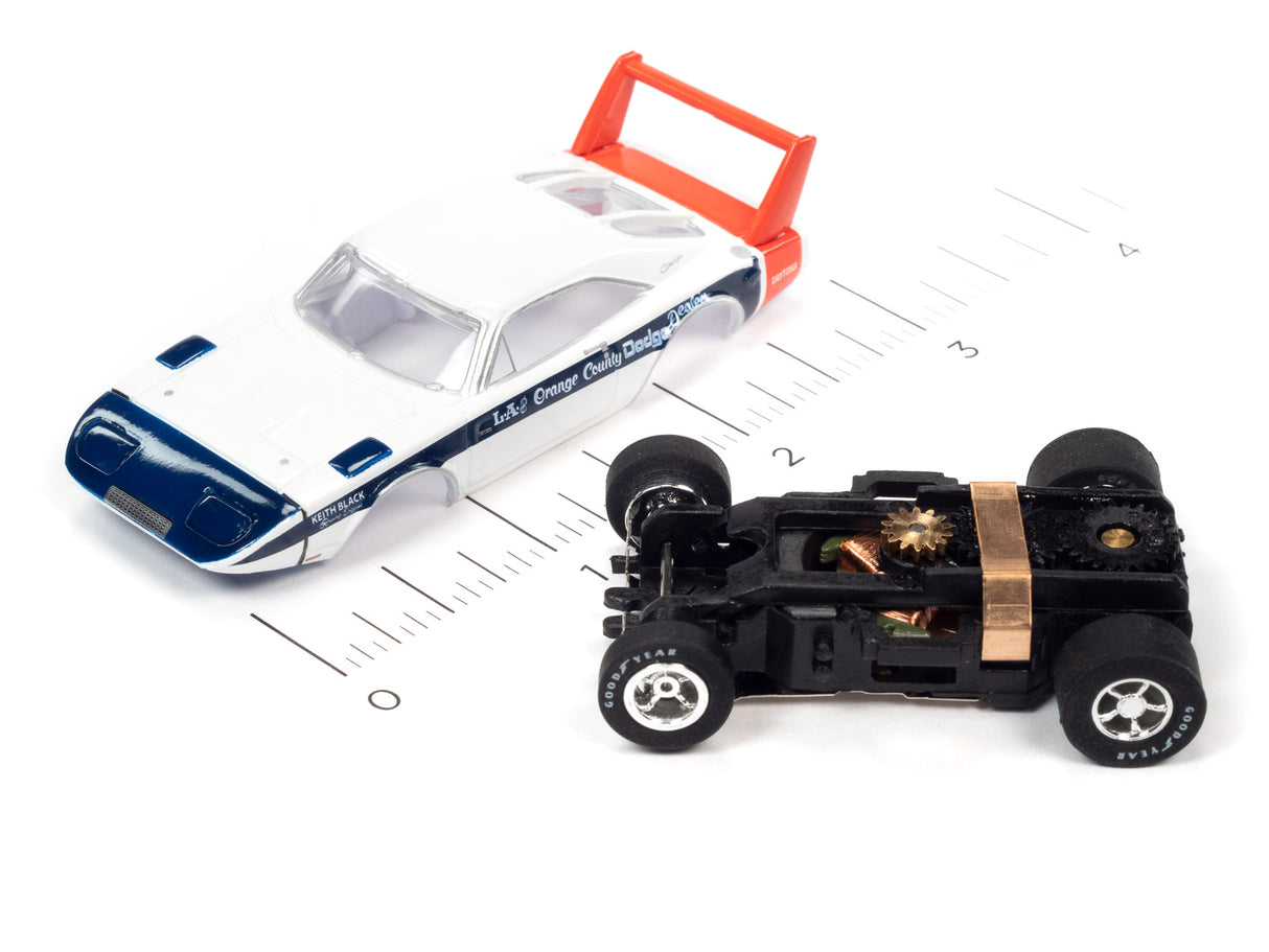 White and blue slot car with red rear spoiler next to a black car chassis for Auto World SC373