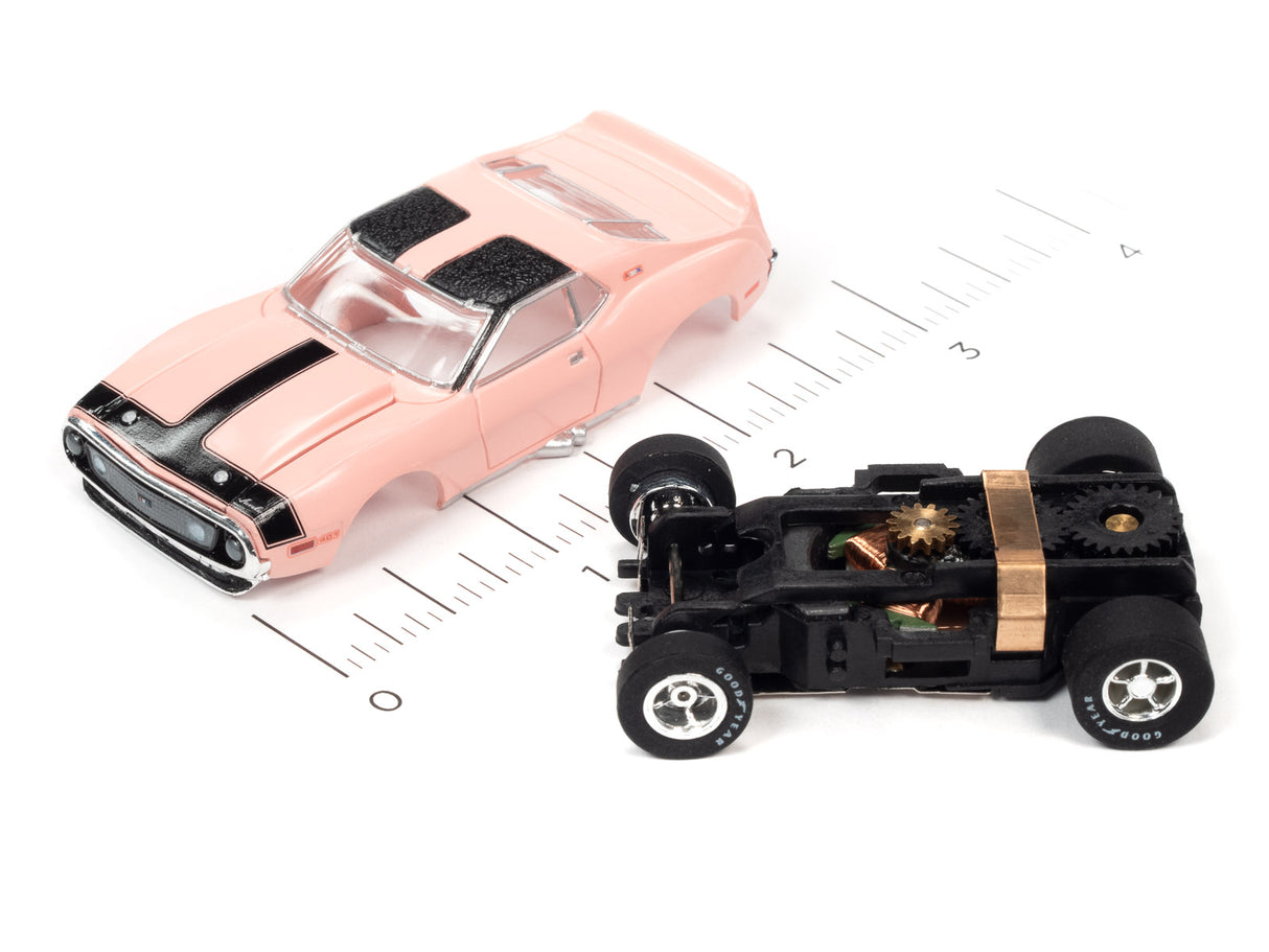 Pink slot car next to its disassembled chassis and wheels for Auto World SC373