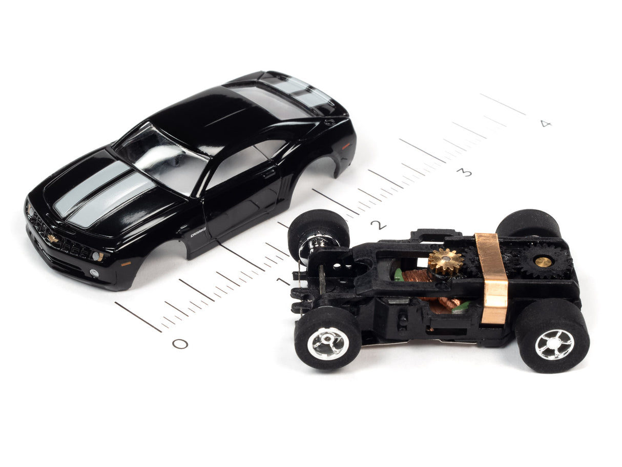 Black slot car and disassembled chassis on a ruler for Auto World SC373