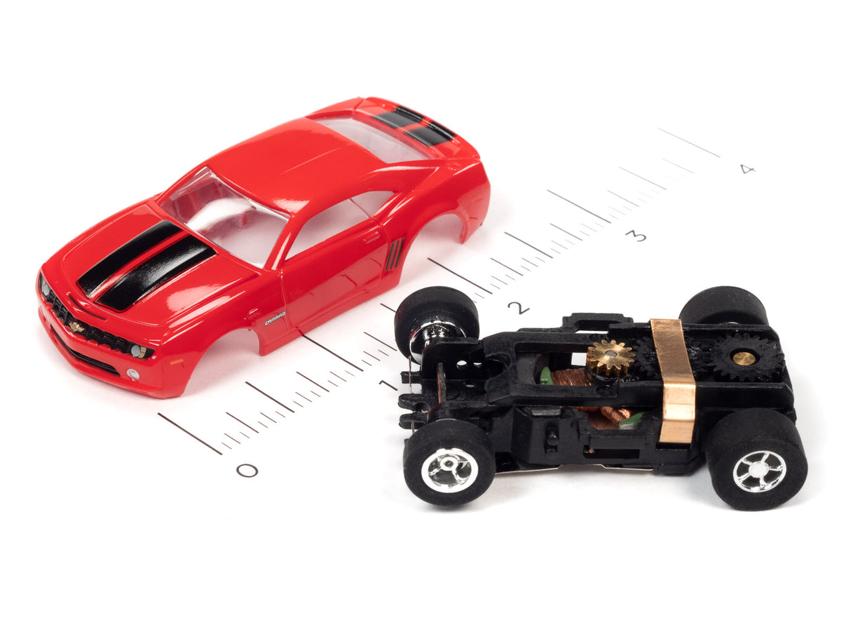 Red slot car and black motorized chassis on a ruler for Auto World SC373