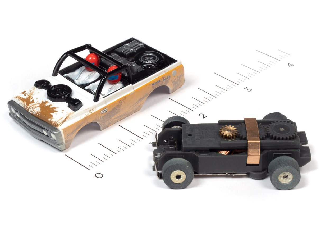 Two slot car off-road vehicles on a ruler for scale comparison for Auto World SC375