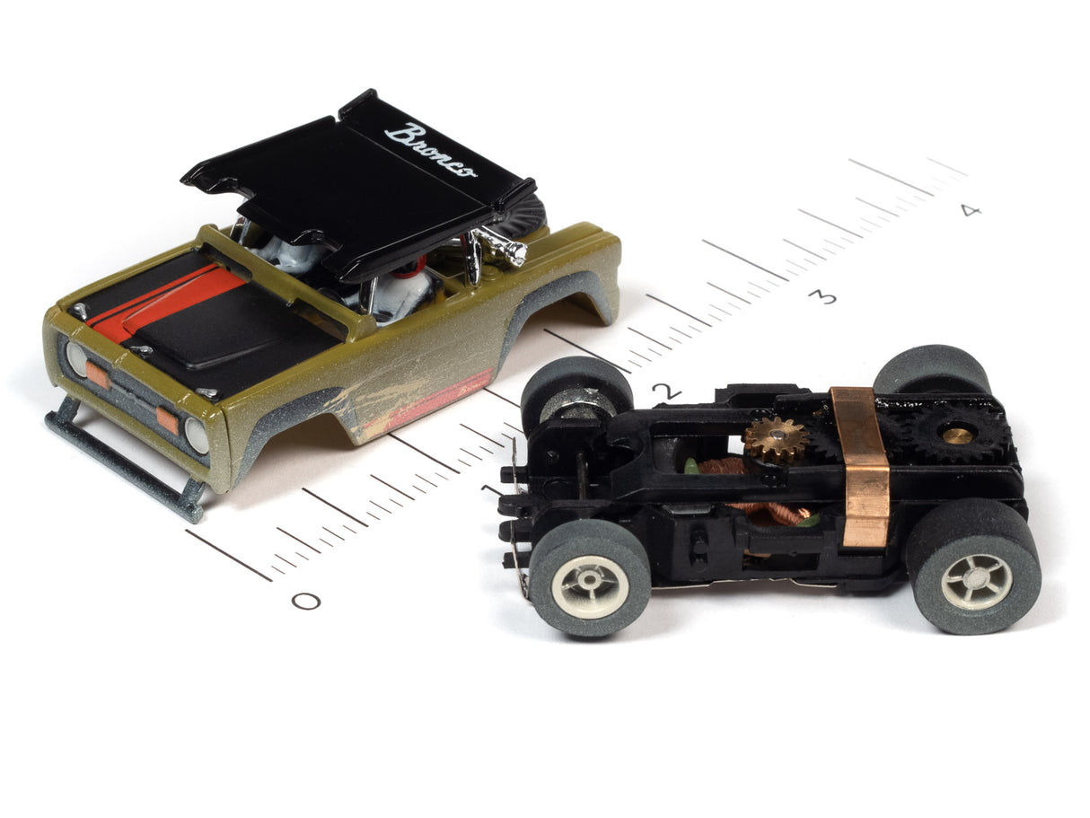 Two slot car off-road vehicles on a ruler scale for Auto World SC375
