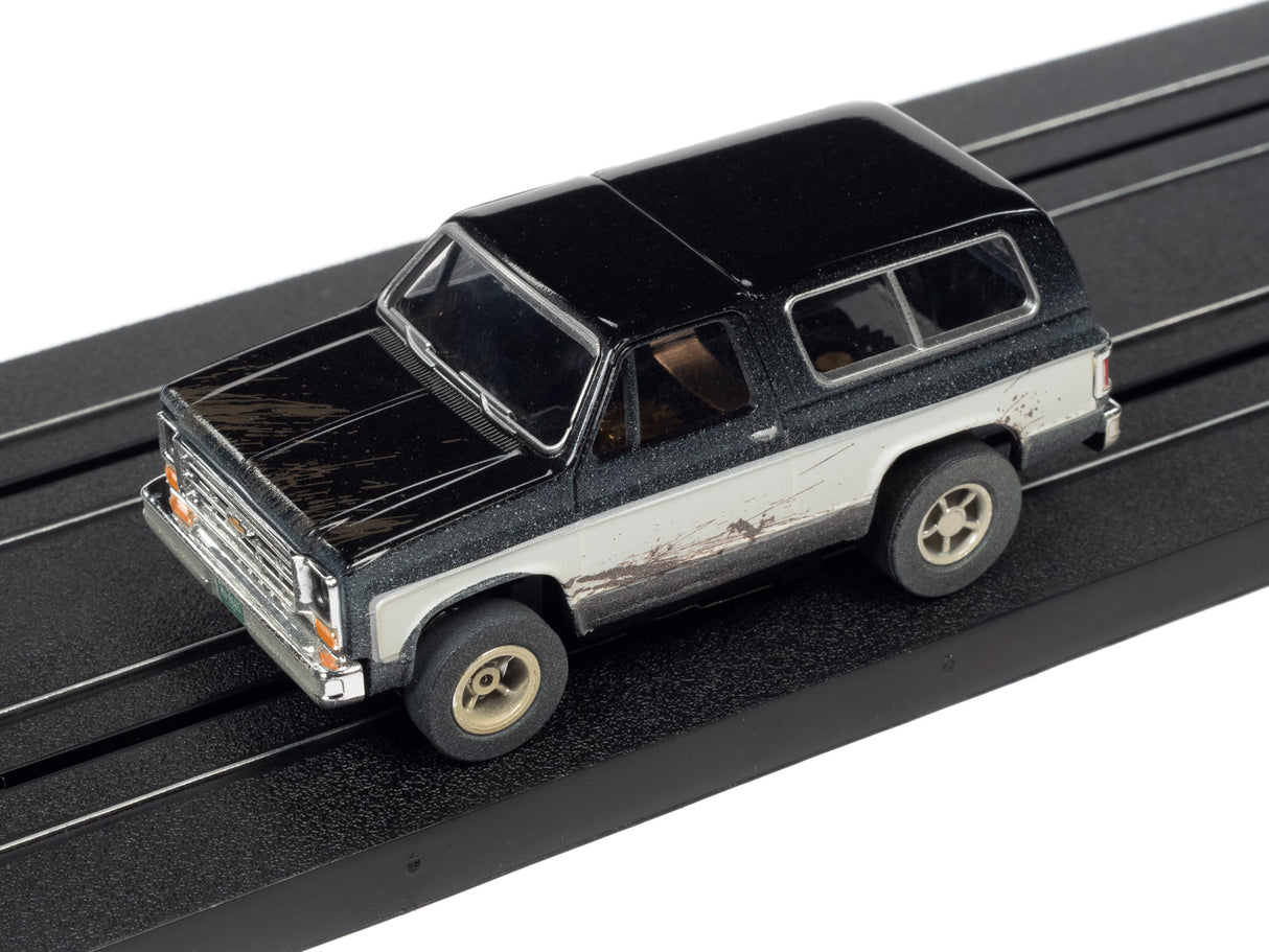 Black and silver slot car truck on a black track for Auto World SC375