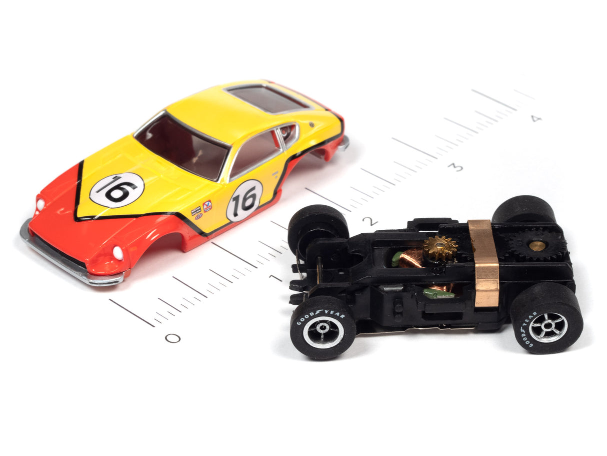 Yellow and red race car toy next to a black slot car on a ruler for Auto World A SC378