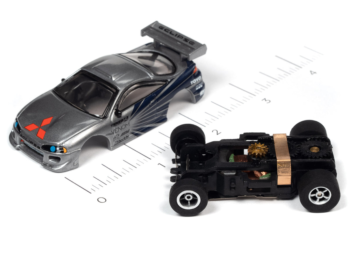 Slot car and chassis components on a ruler for scale reference for Auto World A SC378