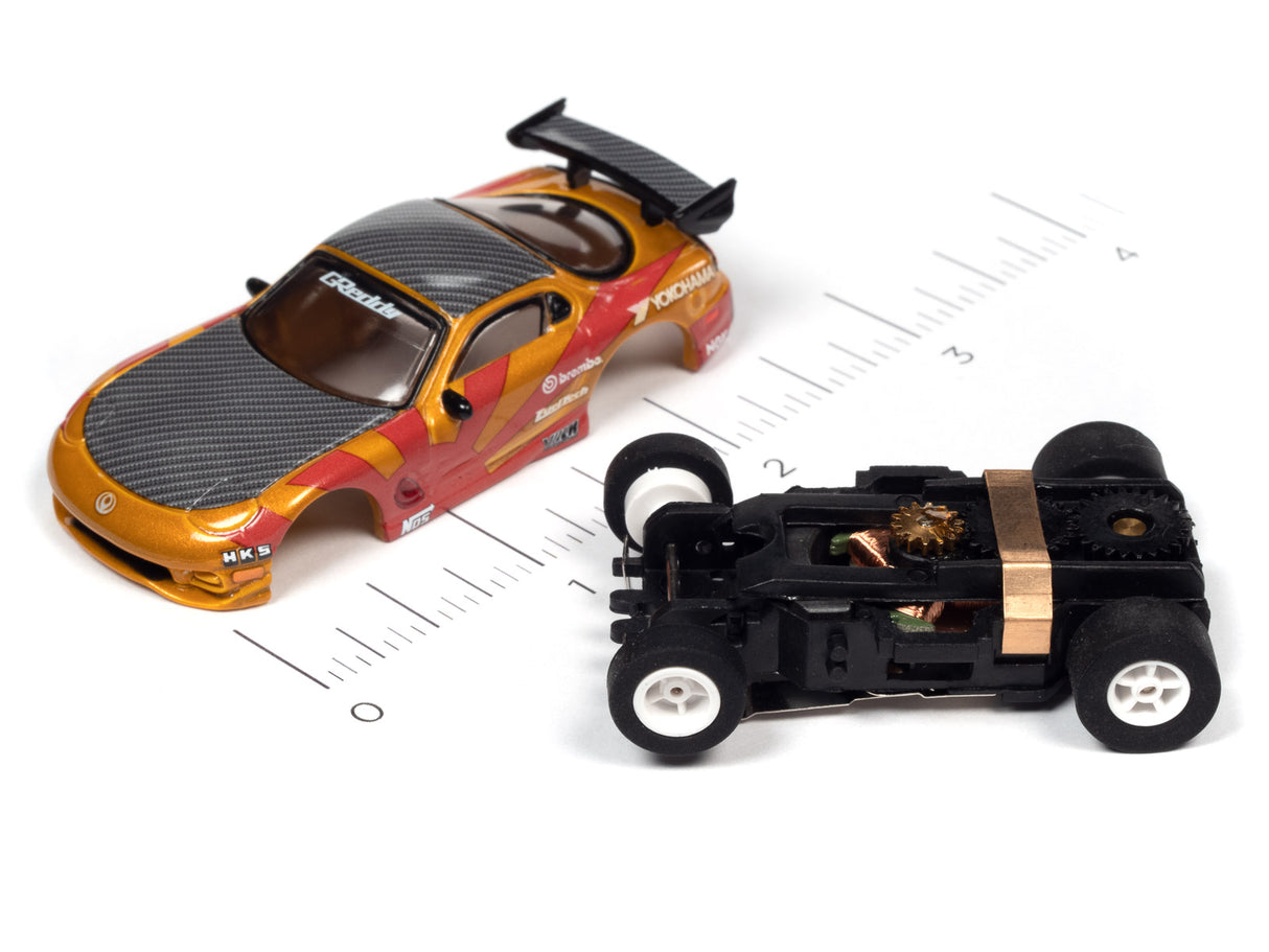 Slot car race car and chassis parts on a ruler for scale for Auto World A SC378