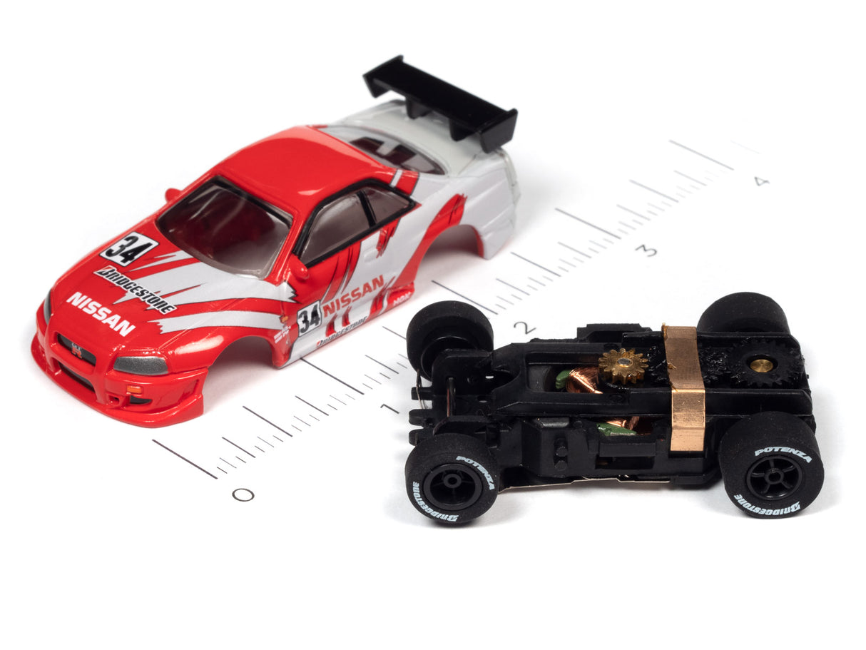 Red Nissan race car next to its disassembled chassis on a ruler for Auto World A SC378