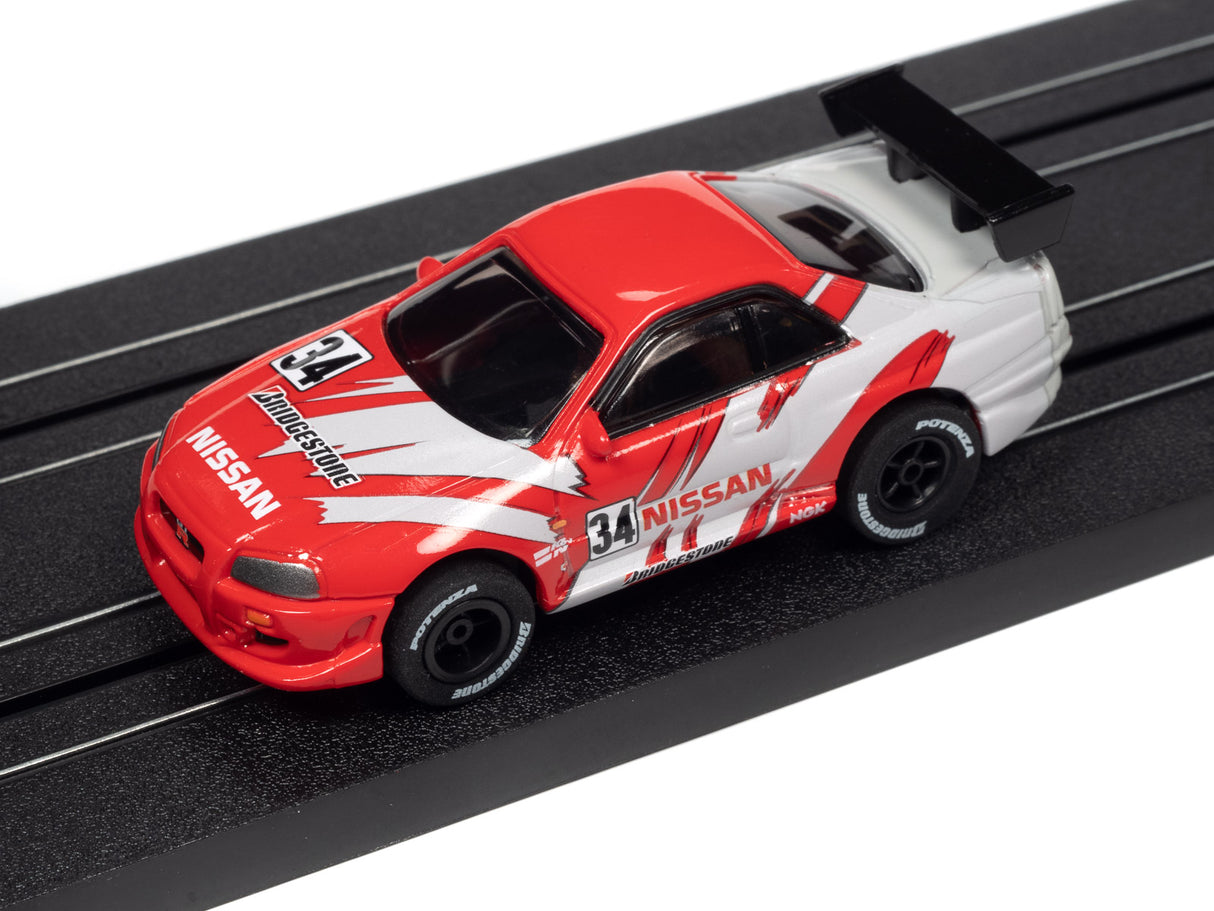 Red and white Nissan race car model on a black track for Auto World A SC378