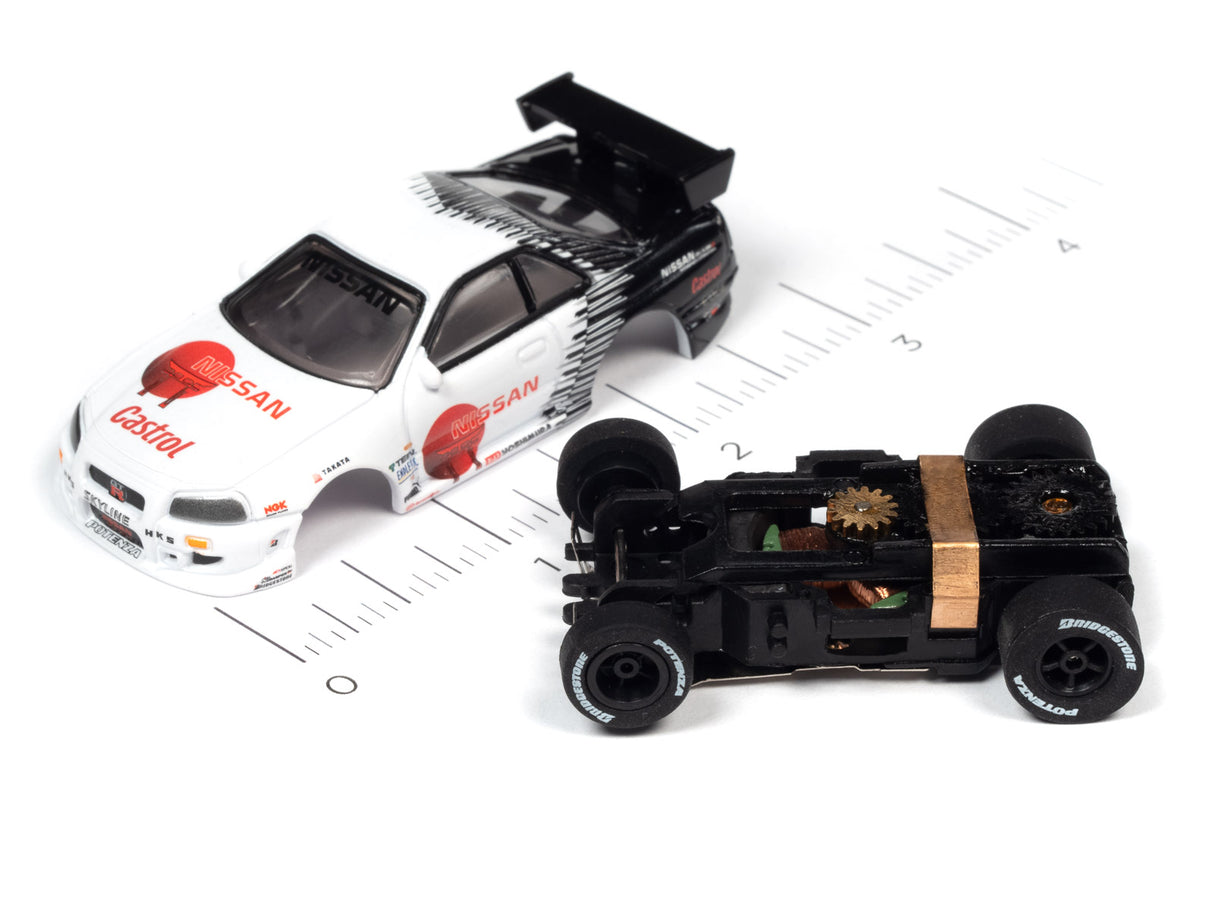 White Nissan race car model next to its disassembled chassis for Auto World A SC378