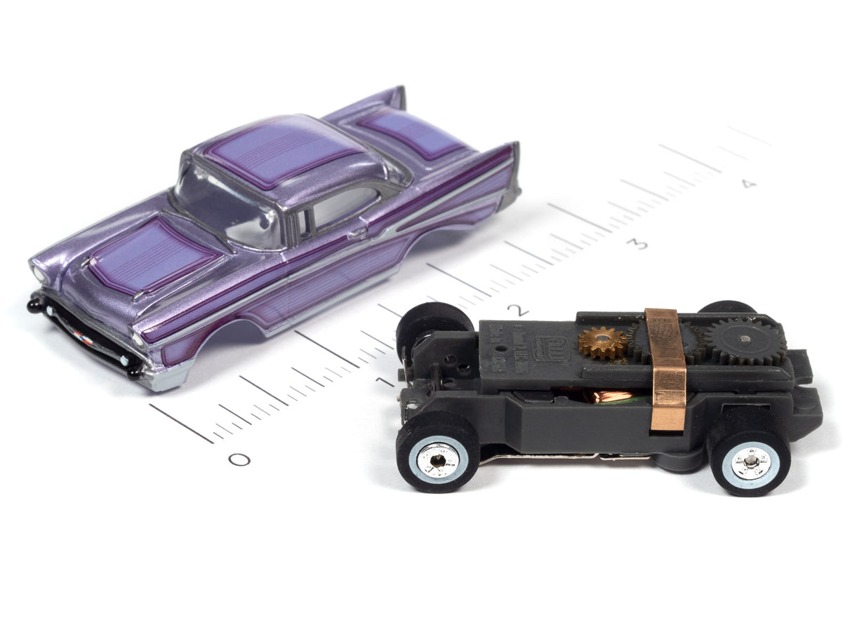 Two slot cars, a purple coupe and a black, mechanical-looking vehicle, on a ruler for Auto World SC379
