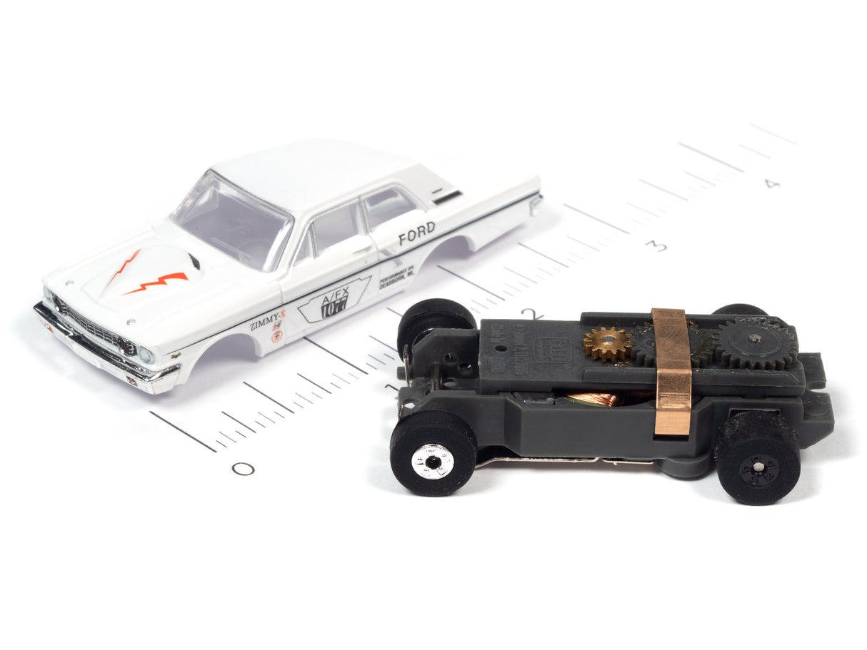 Two slot cars: a white Ford sedan and a black, stylized vehicle for Auto World SC379