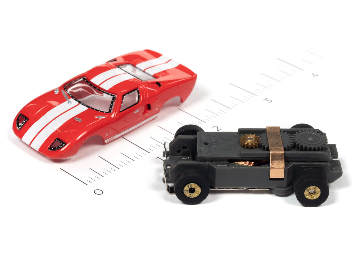 Red sports car and black toy car on a ruler for scale for Auto World SC379