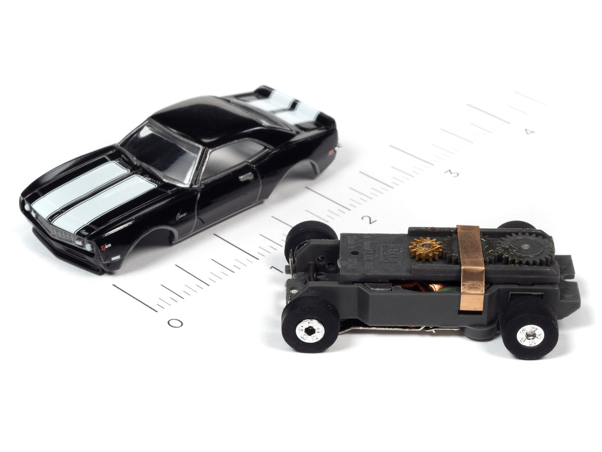 Black toy car and exposed engine mechanism on a ruler for Auto World SC379