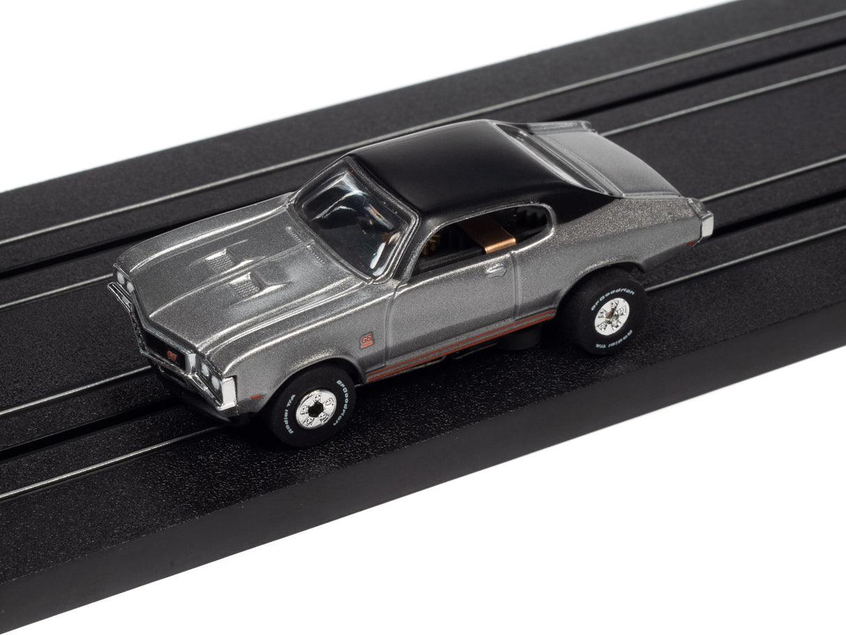 Silver and black slot car on a black track for Auto World SC379