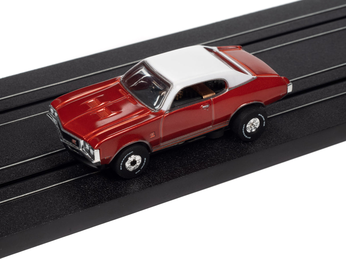 Red and white slot car on a black track for Auto World SC379