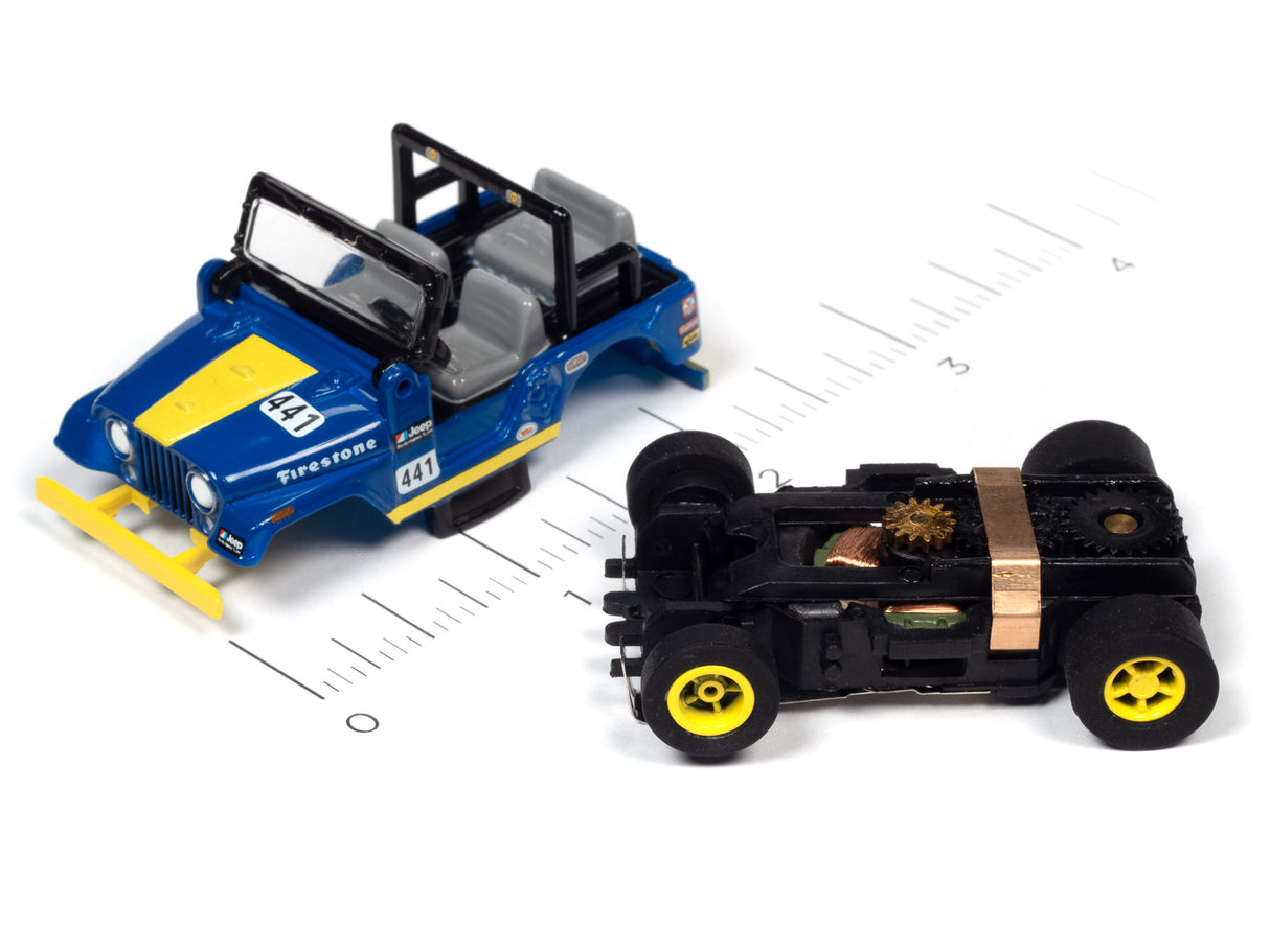 Blue and black toy race car next to a black and gold toy car on a ruler for Auto World SC380