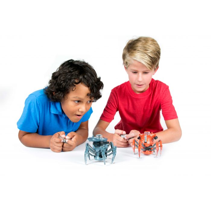 Two boys interact with small, robotic toys on a white surface for HexBug 409-5122