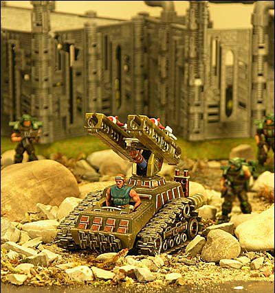 Miniature robot tank with figures, set against a backdrop of stone buildings for Robogear 6003