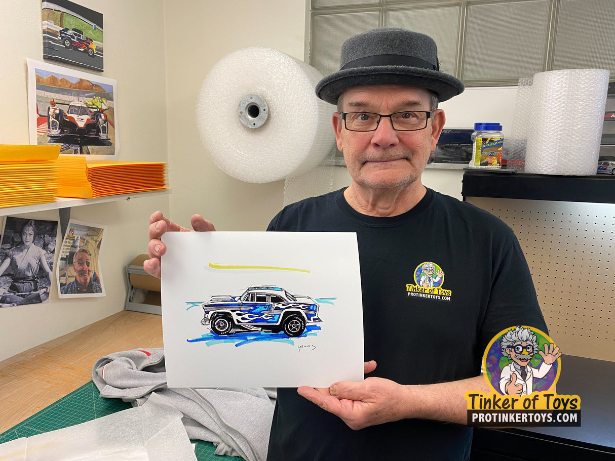 Man holds sketch of blue and white 1955 Chevy Bel Air slot car for Timothy W. Young 8”x10”