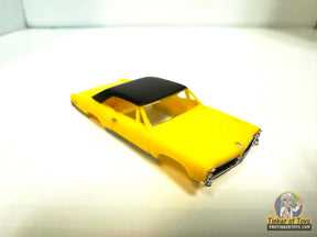 Yellow slot car with a black vinyl top for Model Motoring MM06090