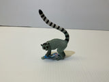 Grey lemur toy with long, striped tail standing on a white surface for Mamejo MAJ55028, front view