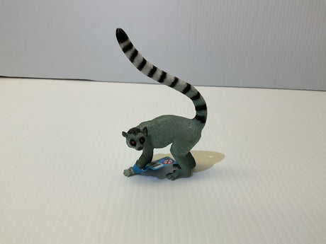 Grey lemur toy with long, striped tail standing on a white surface for Mamejo MAJ55028, front view