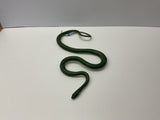 Green, coiled snake toy on a white surface for Mamejo MAJ22210