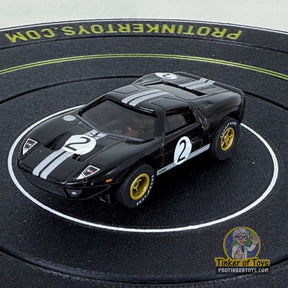 Black Ford GT toy car with white racing stripes on a black track for Auto World CP7990