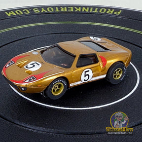 Gold Ford GT toy car with number 5, displayed on a black circular mat for Auto World CP7991, front view