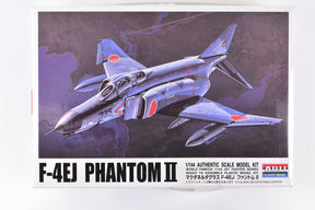 Blue F-4EJ Phantom II jet model kit against a dark, dramatic sky backdrop for Arii