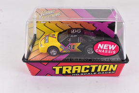 Slot car in box, featuring a yellow and black Chevy Monte Carlo