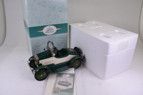 Green and white vintage toy car next to a white box and card for Hallmark QHG9048
