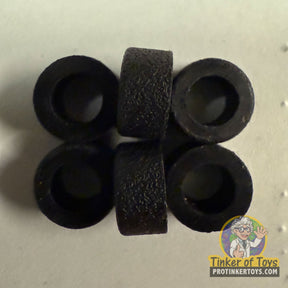 Six black, rubber-like tire rings and two solid black cylinders for Tyco 6693