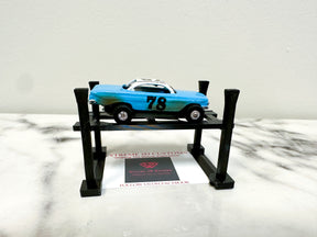 Blue race car on a black, two-level display lift for Extreme 3D Customs HO Scale