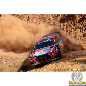 Hyundai i-20 WRC rally car kicking up dust on a dirt track for SCX Advance E10500X300