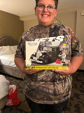 Man holding a model kit box for a German Staff Car Type 230 for COBI COBI2277