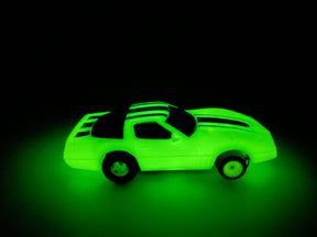 Glowing toy car with blue stripes, illuminated against a dark background for Tyco B15012, front view