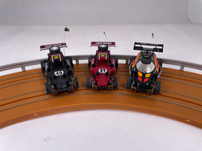 Three vintage slot car dune buggies: black, red, and black/yellow for Tyco B7122